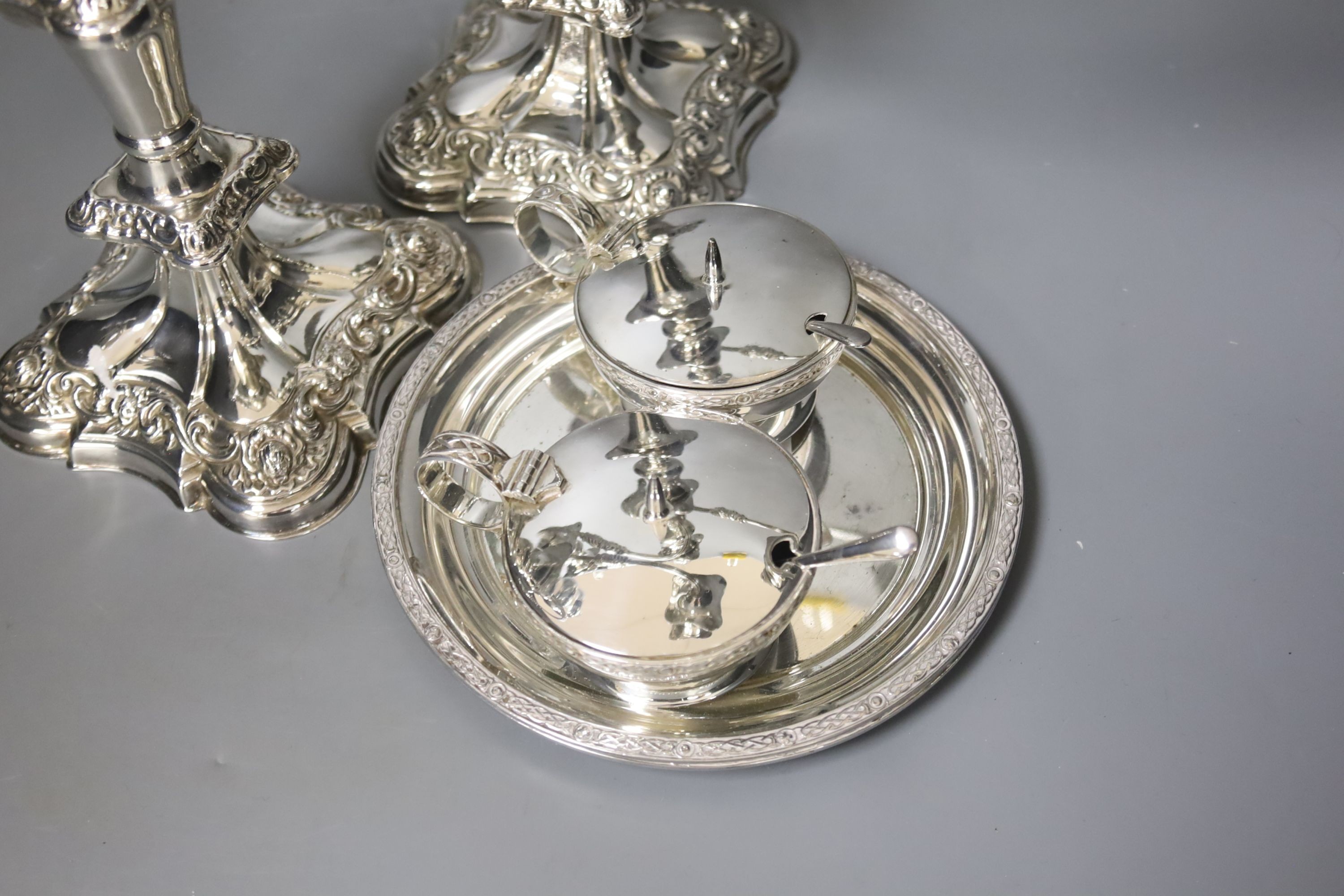 A pair of silver plated candelabra, two plated salvers and two plated mustard pots